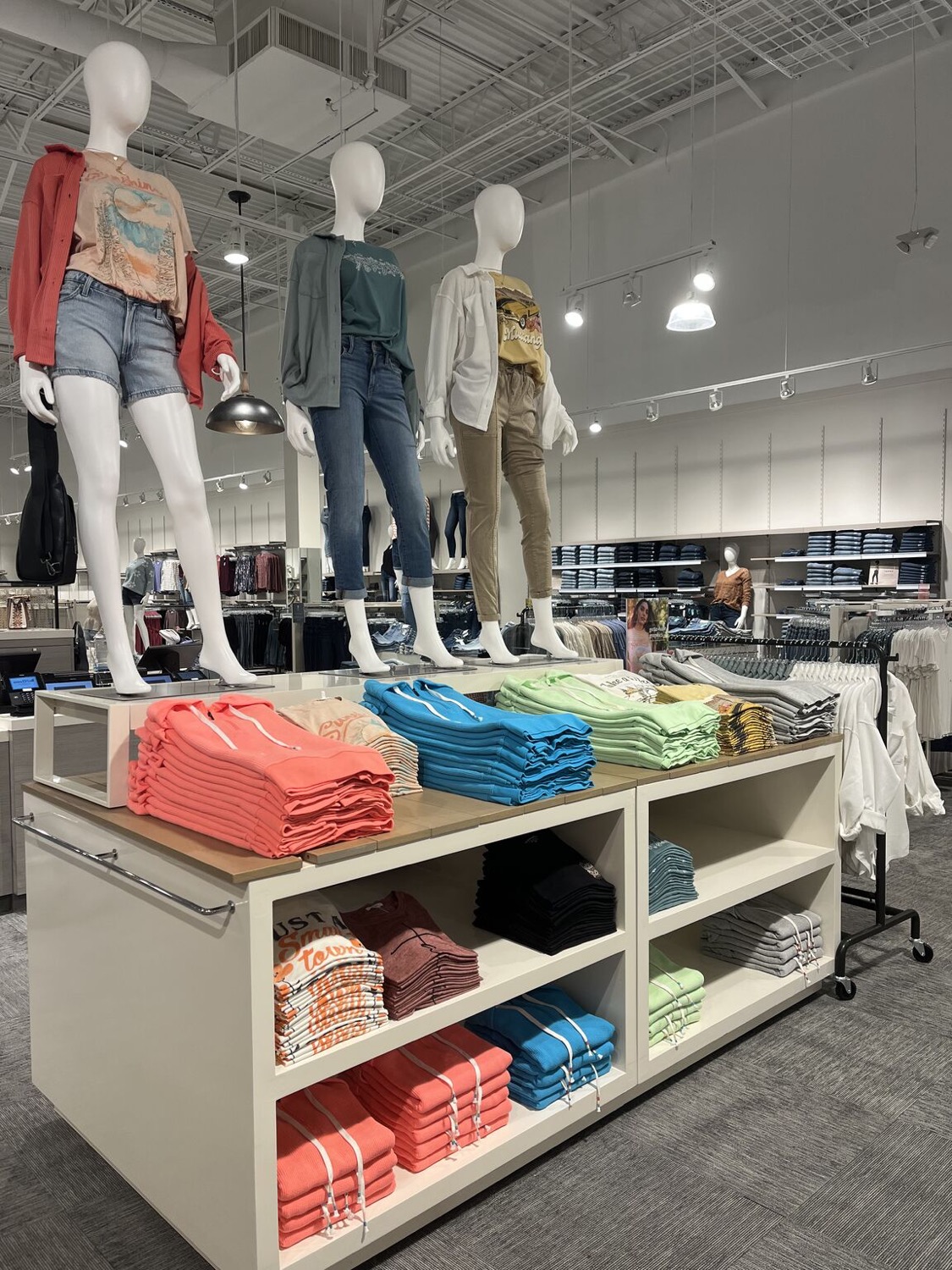 Maurices Muncy store visual merchandising — styled tee table and mannequins
